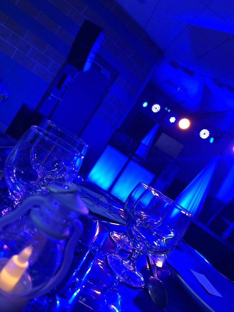 Salle de mariage avec éclairage architectural bleu et tables dressées